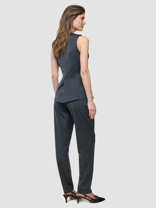 En kvinna står klädd i en ”Women’s Skye Long Vest Charcoal Melange” och matchande byxor.
