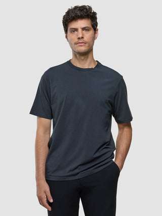 En man klädd i en Supima-T-shirt i modell Box Fit, färgen Deep Grey, med 360°-stretch.