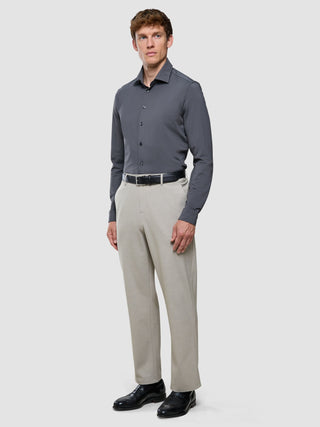 En man klädd i en Travel Shirt i färgen Charcoal Grey Slim, beige byxor, ett svart bälte och svarta kostymskor.