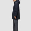 En man klädd i en svart Utility Jacket och svarta och grå byxor.