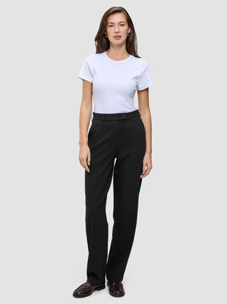 En person som bär en vit t-shirt och byxor av modellen Women GO2 Pants Straight Black med raka ben.