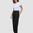 En kvinna klädd i en vit t-shirt, Women GO2 Pants Straight Black och loafers.