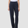 En person klädd i en vit t-shirt, Women GO2 Pants Straight Blue Nights och mörka skor, vilket återspeglar en skandinavisk estetik.