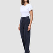 En kvinna bär en vit t-shirt och mörkblå Women GO2 Pants Straight Blue Nights i en rak skärning med skandinavisk design.