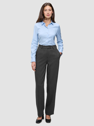 En kvinna klädd i en ljusblå skjorta med knappar och byxor av modellen Women GO2 Pants Straight i mörkgrå melange.