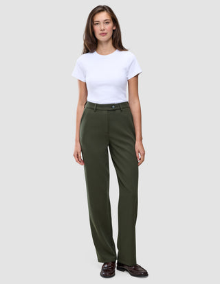 En person som bär en vit t-shirt och ett par Women GO2-byxor i färgen Dusty Olive med raka ben.