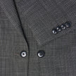 Närbild på damblazern Nara Blazer Fitted Black Check i svartvitt rutmönster med svarta knappar.