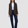 En kvinna bär en Women Serene Blazer Regular Walnut Herringbone, en vit t-shirt och mörkblå jeans.