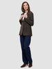 En kvinna klädd i en Women Serene Blazer Regular Walnut Herringbone, en vit t-shirt och mörkblå jeans.