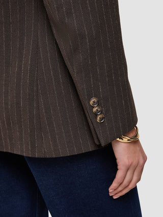 Närbild på en brun Women Serene Blazer Regular Walnut Herringbone-kavaj med tre knappar och ett guldarmband.