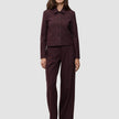 En kvinna bär en kort jacka av modellen Women Serene i färgen Berry Pinstripe tillsammans med matchande byxor med vida ben i skandinavisk design.