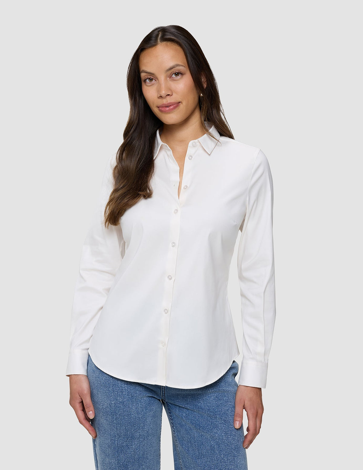 En kvinna klädd i en vit Oxford-skjorta i modellen White Orchid Slim för damer och blå jeans.