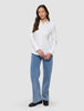 En kvinna klädd i en vit Oxford-skjorta i modellen White Orchid Slim och blå jeans.