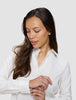 En kvinna klädd i en damskjorta av modellen Oxford Shirt White Orchid Slim som justerar manschetten.