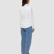 Bakifrånbild av en person som bär en vit Women’s Oxford Shirt White Orchid Slim instoppad i ljusblå jeans.