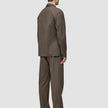 En man sedd bakifrån, klädd i en brun Atelier Overshirt Dark Beige och matchande byxor samt mörka loafers.