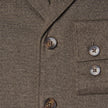 Närbild på den mörkbeige Atelier-överskjortan i bruten twill med två knappar framtill och två på bröstfickan.