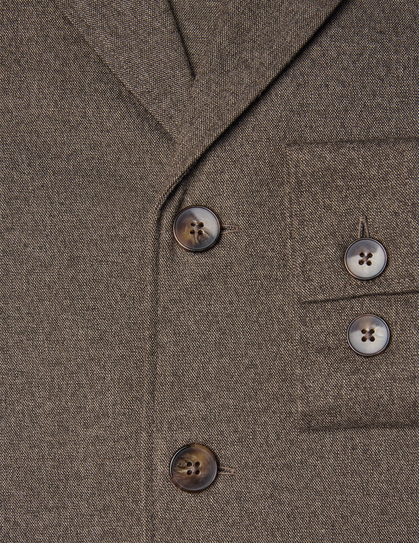 Närbild på den mörkbeige Atelier-överskjortan i bruten twill med två knappar framtill och två på bröstfickan.