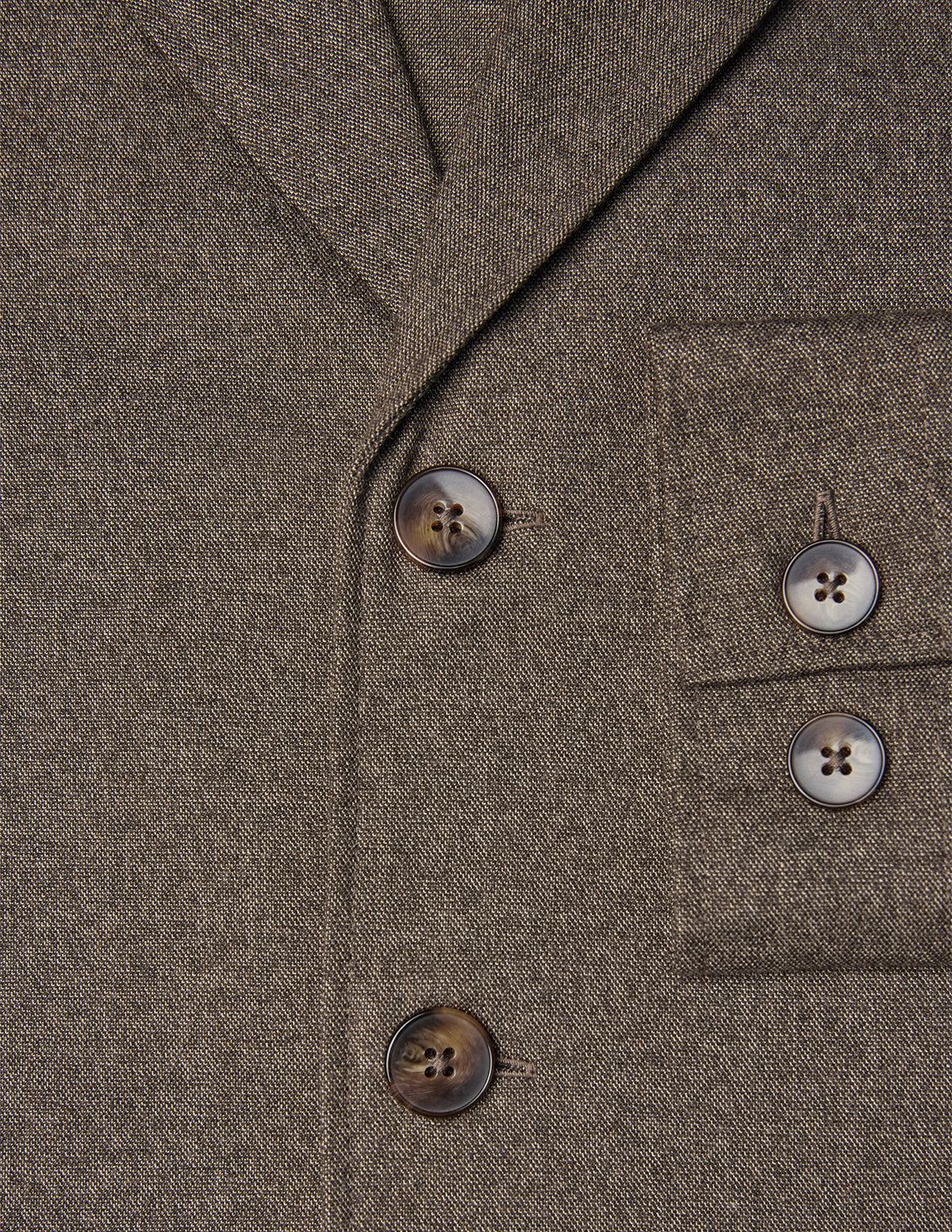 Närbild på den mörkbeige Atelier-överskjortan i bruten twill med två knappar framtill och två på bröstfickan.