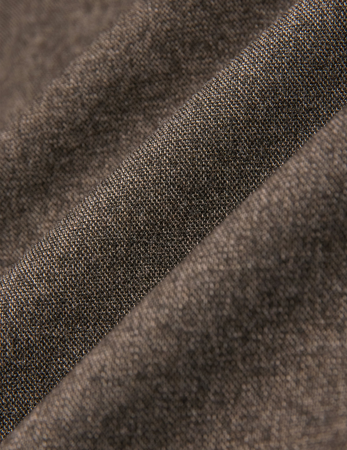 Närbild på Atelier Overshirt Dark Beige, som visar ett tvillvävt tyg med synliga veck i vävnaden.