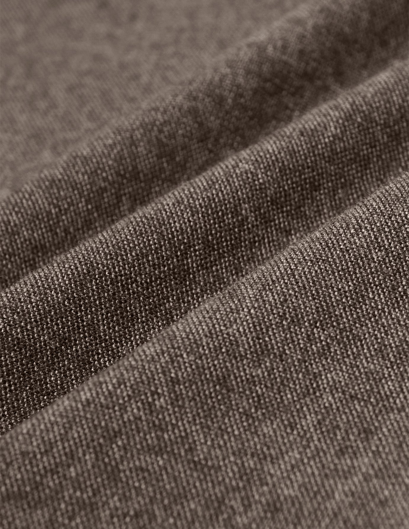 Närbild på ett brunt, strukturerat twilltyg i modellen Atelier Pants Relaxed Dark Beige med synlig vävstruktur och mjuka veck.