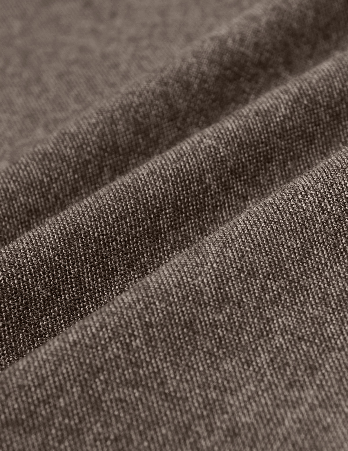 Närbild på ett brunt, strukturerat twilltyg i modellen Atelier Pants Relaxed Dark Beige med synlig vävstruktur och mjuka veck.