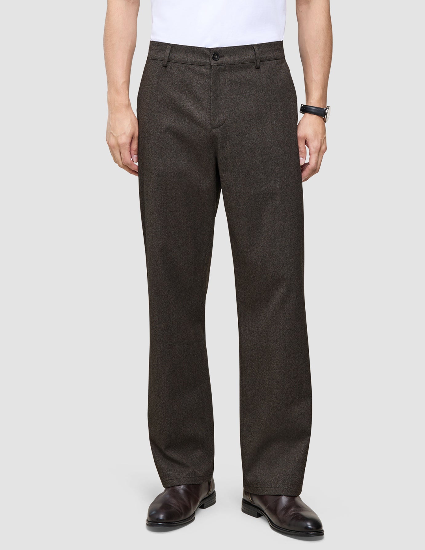 Atelier-byxor i avslappnad passform, mörkbruna i bruten twill, kombinerade med en vit skjorta och mörka läderskor.