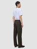 En man sedd bakifrån, klädd i en vit t-shirt och mörkbruna Atelier Pants Relaxed.