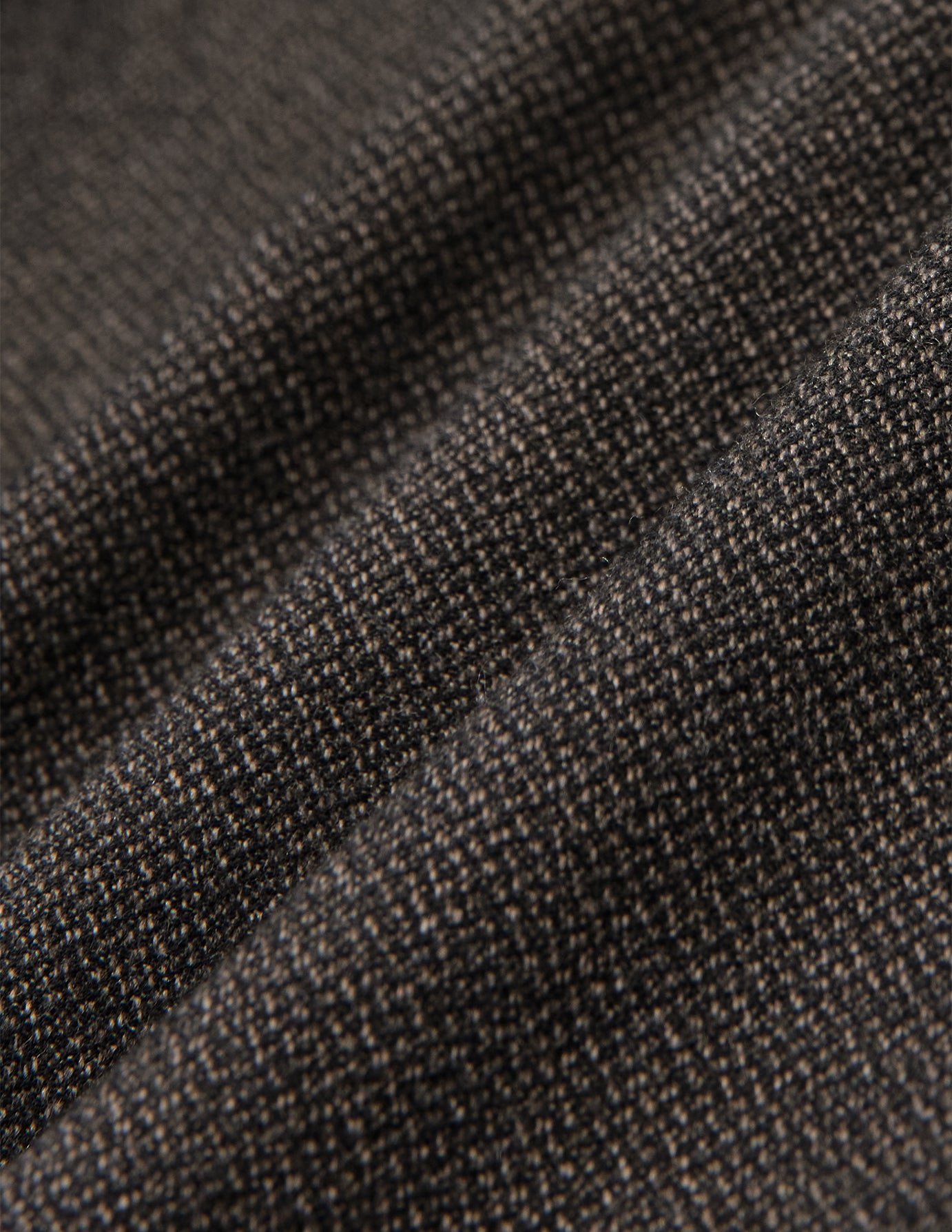 Närbild på det mörkbruna, brutna twilltyget i modellen Atelier Pants Relaxed Dark Brown, som visar en fin, strukturerad vävning.
