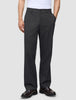 Mörkgråa byxor i avslappnad passform, modell Atelier Pants Relaxed Dark Grey, i bruten twill med knäppning och mörka läderloafers.
