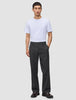 En man klädd i en vit t-shirt och byxor av modellen Atelier Pants Relaxed Dark Grey i bruten twill.