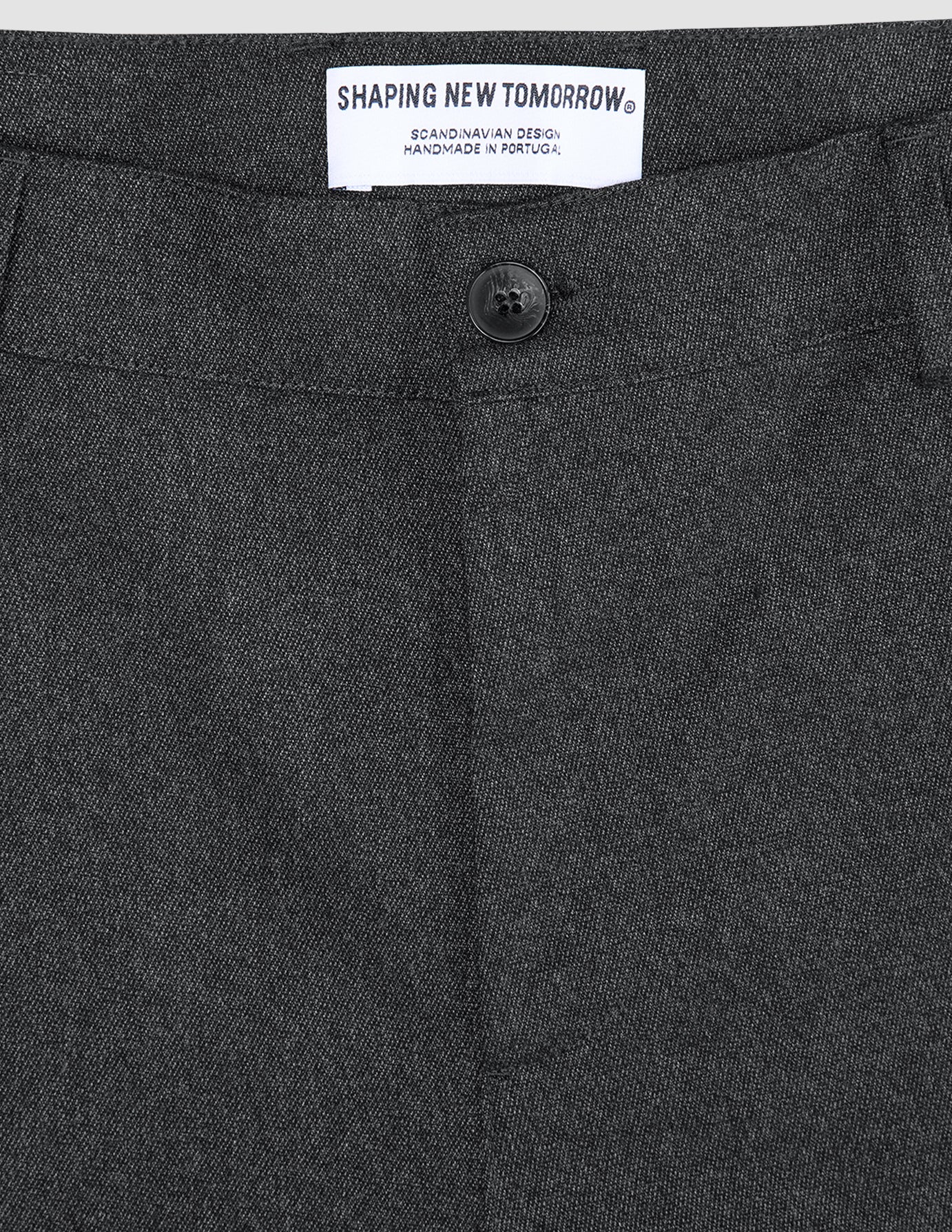 Atelier Pants Relaxed – mörkgrå byxor i bruten twill med knäppning och en märkesetikett på insidan av midjebandet.