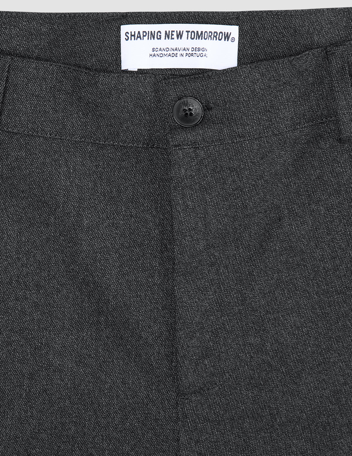 Atelier Pants Relaxed – mörkgrå byxor i bruten twill med knäppning och en märkesetikett på insidan av midjebandet.