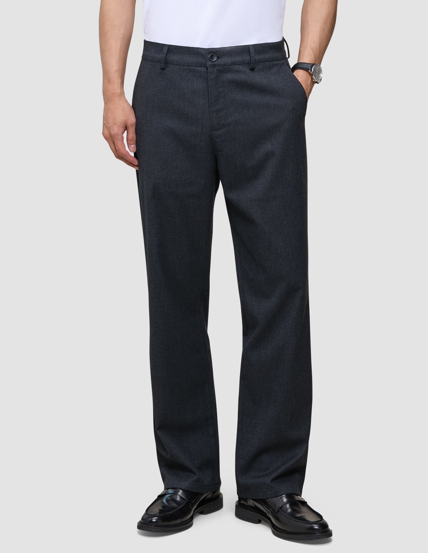 En person som bär marinblåa Atelier Pants Relaxed Dark Navy i bruten twill med avslappnad passform och svarta kostymskor.