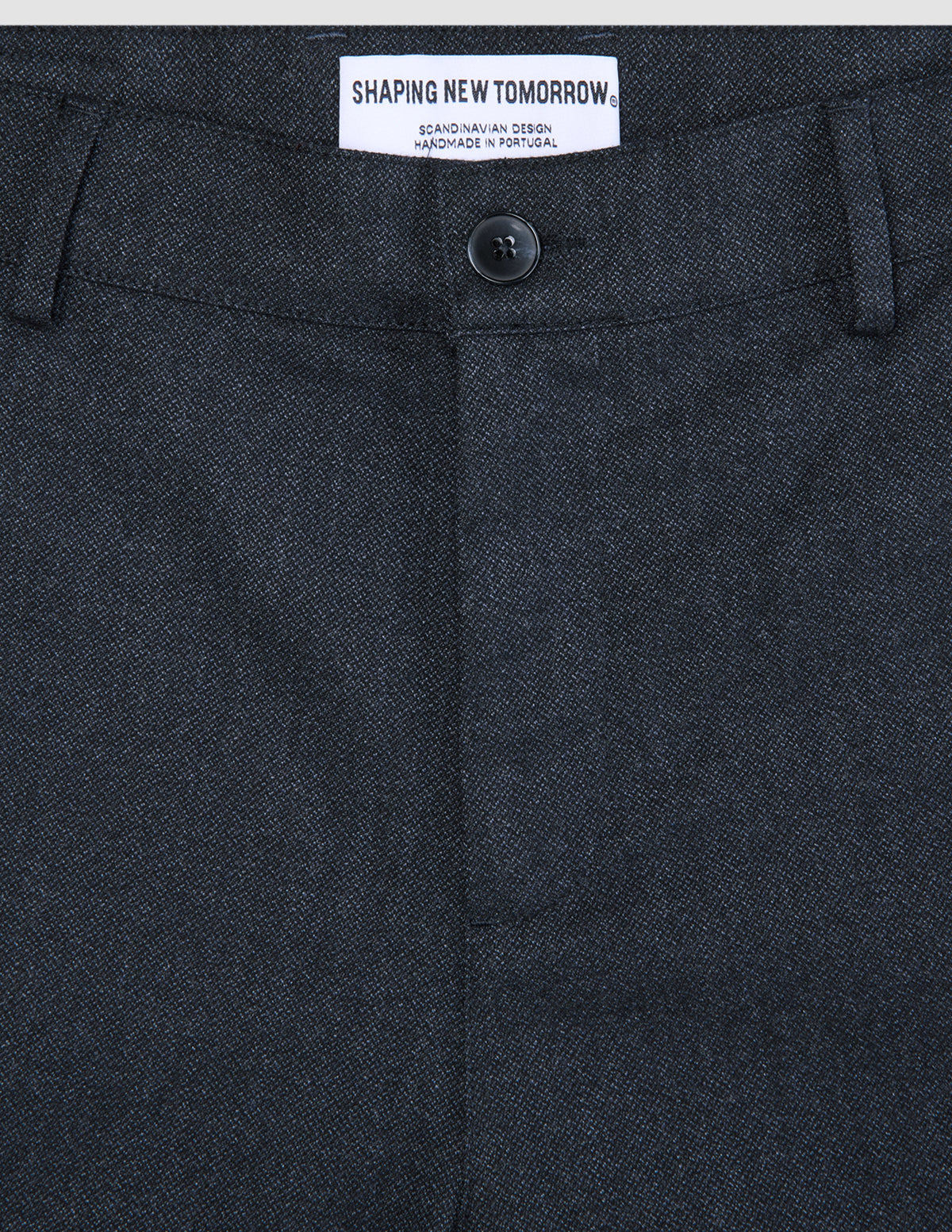 Närbild på byxorna Atelier Pants Relaxed Dark Navy i bruten twill med knäppning och invändig märkesetikett.