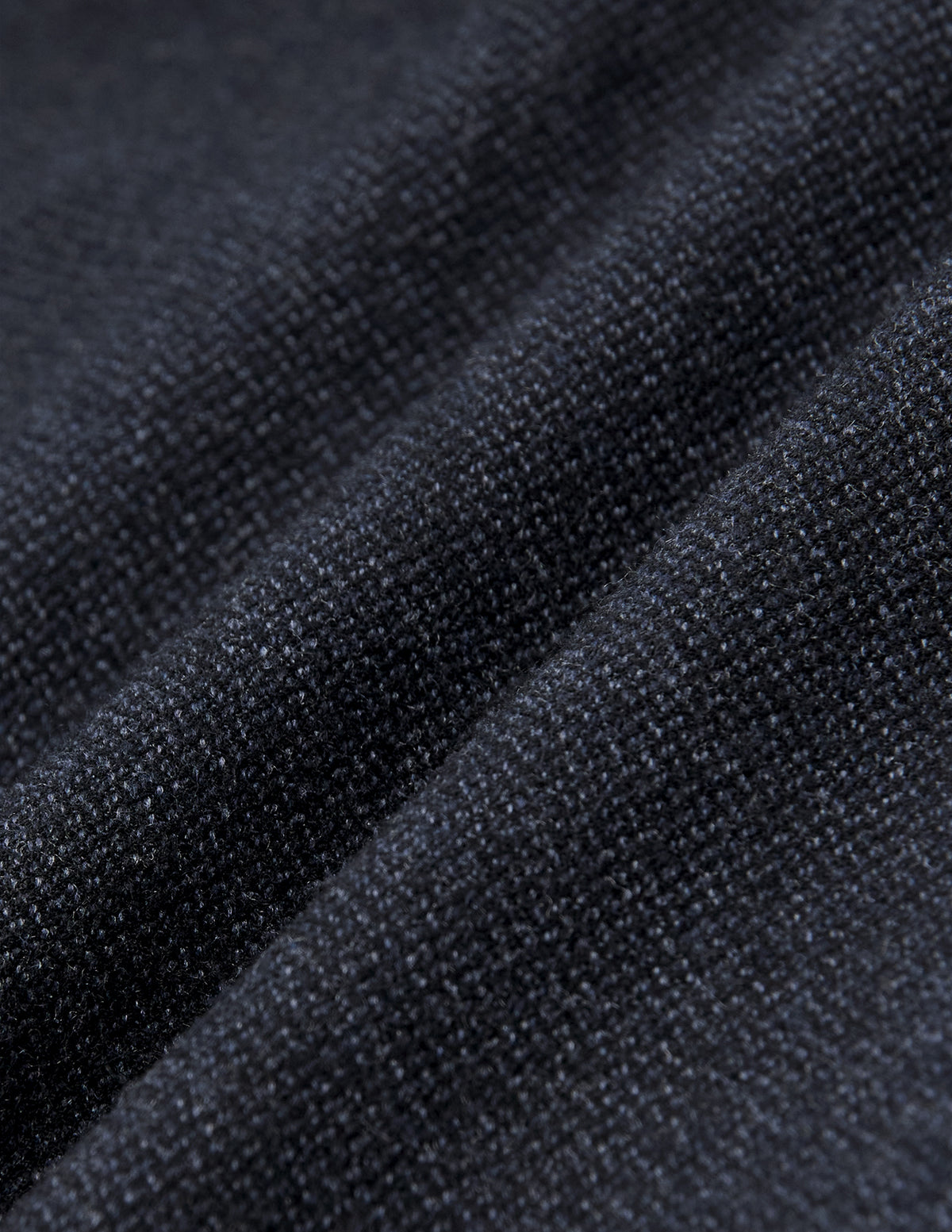 Närbild på byxorna Atelier Pants Relaxed Dark Navy i mörk marinblått, tillverkade i ett strukturerat, vävt brutet twilltyg med skandinavisk design.