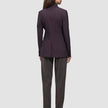 En kvinna sedd bakifrån, klädd i en mörk vinröd Women’s Avira Blazer Burgundy Berry och byxor i kolgrått.