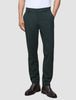 En person som bär mörkgröna Ease Pants Regular Northern Pine och bruna läderstövlar.