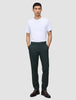 En man i en vit t-shirt och Ease Pants Regular Northern Pine med händerna i fickorna.