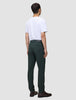 En person sedd bakifrån, klädd i en vit t-shirt, Ease Pants Regular Northern Pine och bruna kostymskor.