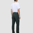 En person sedd bakifrån, klädd i en vit t-shirt, Ease Pants Regular Northern Pine och bruna kostymskor.