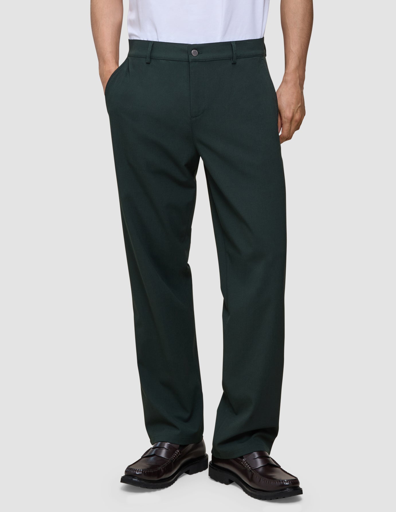 En person bär byxorna Northern Pine Ease Pants Relaxed Fit tillsammans med bruna loafers i en bekväm, skandinaviskt inspirerad design.