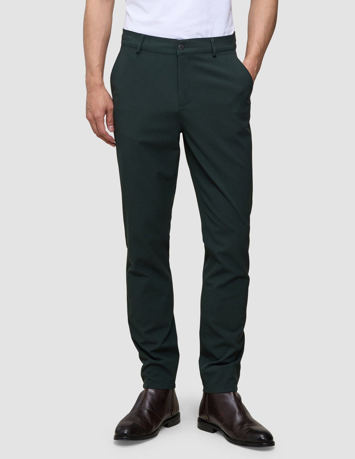 Mörkgröna Ease Pants Slim i färgen Northern Pine med smal passform, kombinerade med bruna läderstövlar.