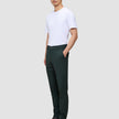 En man bär en vit t-shirt, Ease Pants Slim Northern Pine och mörka läderskor.