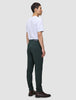 En person klädd i en vit t-shirt, Ease Pants Slim Northern Pine och bruna läderstövlar.