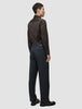 En man sedd bakifrån i en mörkbrun skjorta av modellen Elevated Shirt Regular, instoppad i kolgrå byxor och mörka loafers.