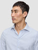 En man klädd i en Elevated Shirt Slim Classic Blue Striped – en smalpassad, ljusblå och vitrandig skjorta med knappar.