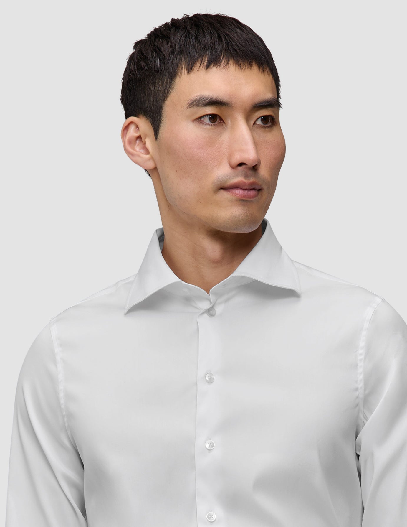 En man klädd i en Elevated Shirt White Slim, en vit skjorta med smal passform och utbredd krage i minimalistisk design.