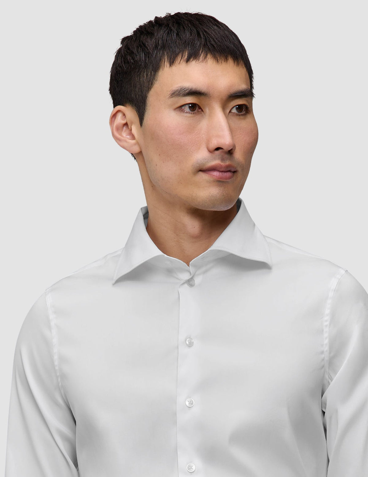 En man klädd i en Elevated Shirt White Slim, en vit skjorta med smal passform och utbredd krage i minimalistisk design.