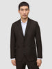 En man bär en mörkbrun tvåknappsblazer av modellen Motion Blazer Slim Cognac över en vit skjorta med krage.